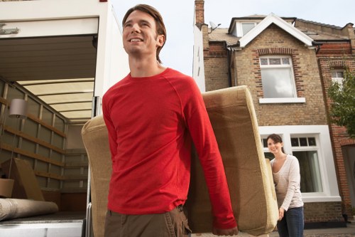 Helper carrying household items from a flat in West Kensington