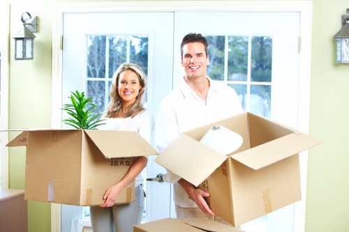 Professional movers carrying household items through a West Kensington property entrance